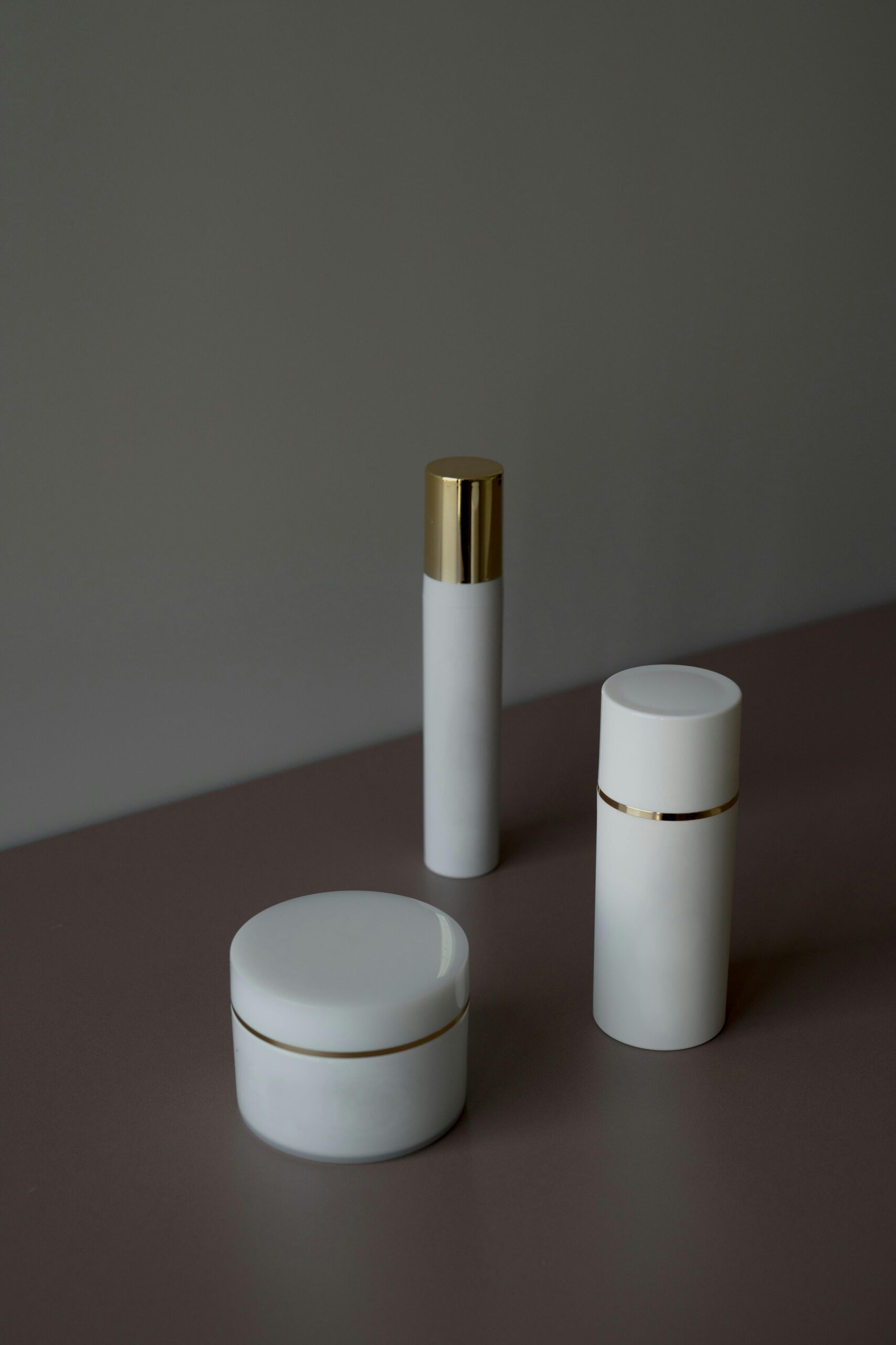 Elegant minimalist shot of skincare product containers with a gray background.